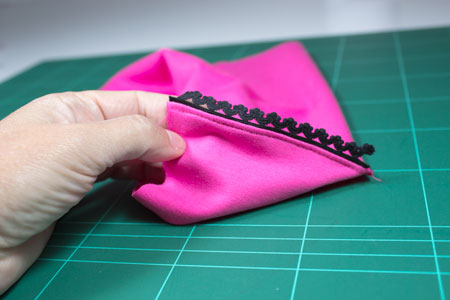 Puntilla elastica negro sobre tela rosa